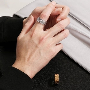 Close-up of vintage wide band rings featuring woven texture in silver and gold metal