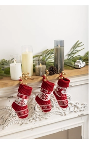 Close-up of red and white knitted Christmas stockings with snowflakes on a cozy fireplace