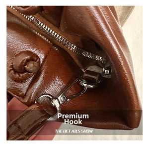 Detail of premium silver metal hooks and zipper on the brown pleated leather cloud bag