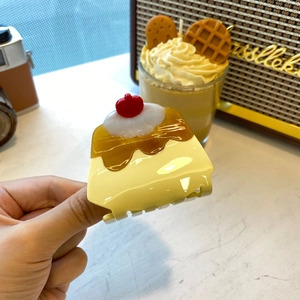 Close-up of a cute pudding-shaped hair claw clip with cherry and cream details