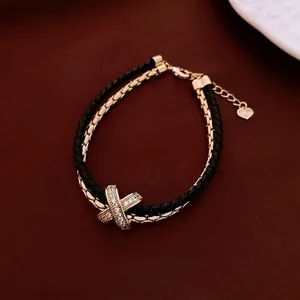 Minimalist double-layer leather and gold bracelet with pavé zircon X-buckle design