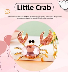 Detail of crab keychain with pink crystal body and golden legs set with small rhinestones