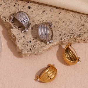Detail of 18K gold and silver plated hoops with textured pattern and small pearls