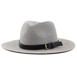 Gros plan du chapeau de paille Panama gris avec bandeau noir et boucle en métal doré