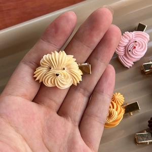 Close-up of cream-piped puppy cookie hair clip with a durable metal duckbill base