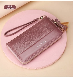 Close-up of dusty pink long wallet with crocodile texture and gold zipper tassel