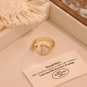 Detail view of 18K gold plated heart ring with white shell in a luxury wooden box