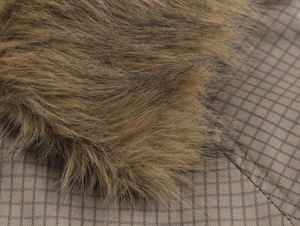 Close-up of the faux fur collar and plaid fabric texture on a women's trench coat