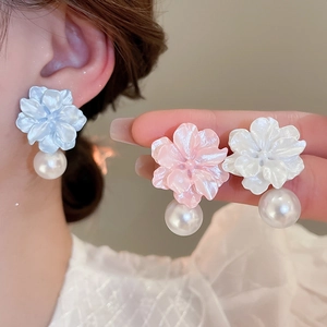 Close-up of resin flower earrings with pearls in blue, pink, and white floral design
