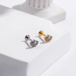 Macro detail of G23 titanium labret studs with opal and zircon flowers on white stone