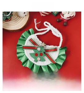 Détail d'un bavoir de Noël tricoté pour animaux avec motif sapin festif et bordure verte