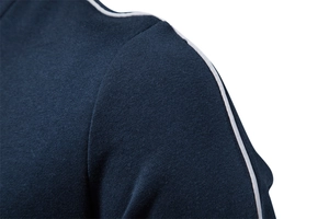Macro detail of navy sports sweatshirt showing white shoulder piping and knit texture