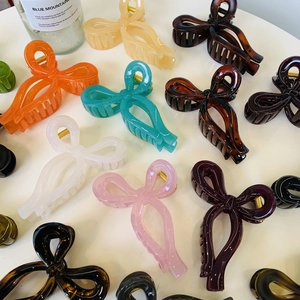 Detailed collection of ribbon-style hair claws in amber, teal, and pink colors