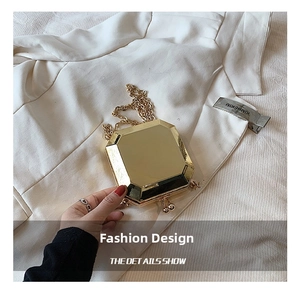 Detail shot of golden mirror acrylic octagonal clutch with metallic chain strap