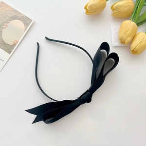 Elegant French style black satin bow headband for women on minimalist background