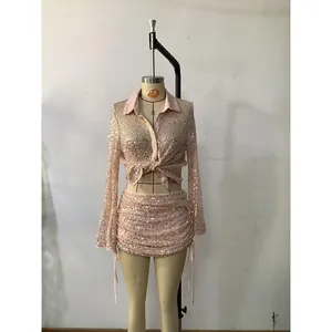 Detail of champagne sequin two-piece set featuring a cropped cardigan and ruched mini skirt