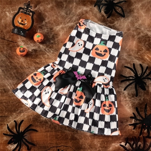 Detail of checkered pumpkin pet dress with satin bow and sequin bat on Halloween props