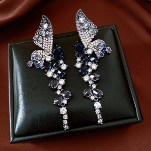 Close-up of vintage butterfly drop earrings with colorful zircons and long tassels