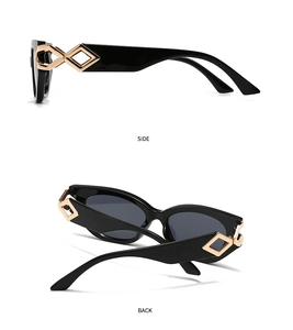 Detail showing the black cat-eye sunglasses with golden diamond-shaped metal trim