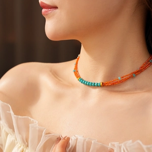 Detail of multi-layer beaded necklace with carnelian and turquoise on a model