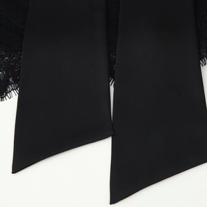 Close-up of black satin ribbon and delicate lace trim on a stylish autumn mini skirt