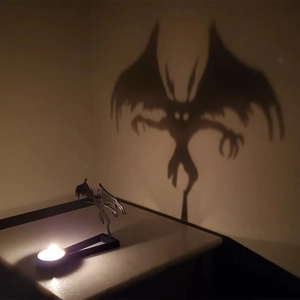 Monster shadow effect cast on a wall by a metal candle holder during Halloween
