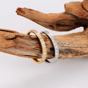 Gold and silver stackable stainless steel rings with full diamond inlay on weathered wood