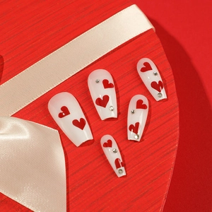 Medium coffin press-on nails with red heart patterns and rhinestones on white base