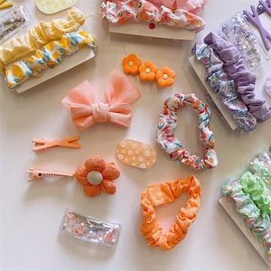 Detailed view of assorted floral fabric hair scrunchies and colorful floral hair clips