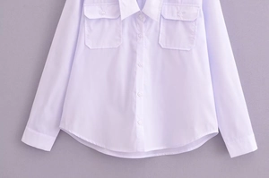Flat lay of a white deep V-neck long sleeve blouse with dual chest flap pockets
