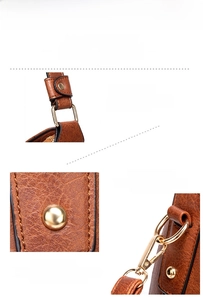 Detailed view of the gold-tone alloy hardware and zippers on a brown tote handbag