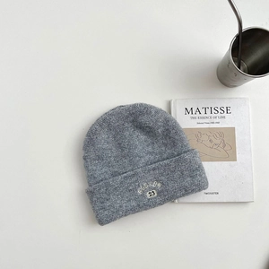 Close-up of grey wool knit beanie with white BOSTON 23 embroidery and soft texture