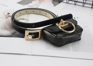 Detail of black leather waist bag with gold circular ring and stylish slim belt