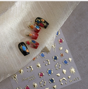 Macro detail of M-911 nail art stickers with golden abstract leopard patterns on tips