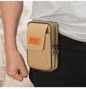 Detail of durable khaki canvas waist bag with dual zippers and velcro pocket worn on belt