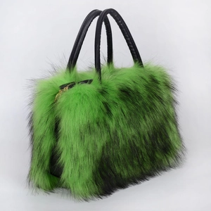 Close-up of fluffy green faux fur texture and black leather handles on a large tote bag