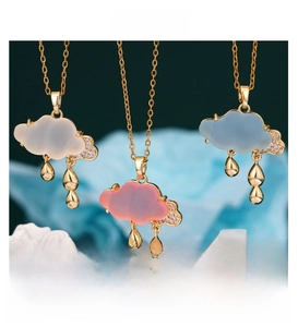 Detail of cloud-shaped pendant necklaces with cubic zirconia and gold teardrop charms