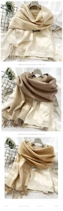 Detail of double-sided cashmere-like scarf with fringe edges in beige and khaki tones