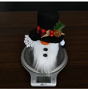 Close-up showing a Christmas gnome decoration on a scale weighing exactly 130.2 grams