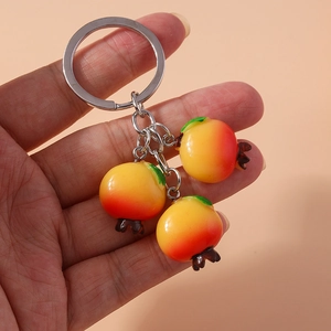 Detailed view of handmade pomegranate fruit keychains with vibrant gradient color resin charms