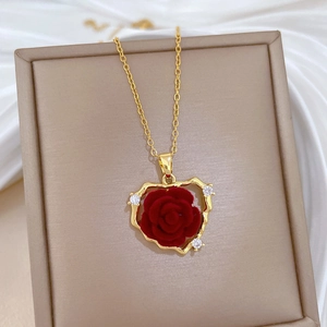 Luxurious gold heart necklace with red flocked rose and sparkling diamonds on silk