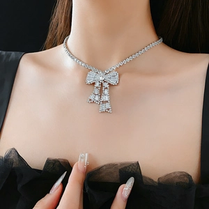 Close-up of sparkling bow pendant necklace with rectangle zircons on a model
