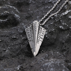 Nordic Viking arrowhead pendant in silver stainless steel on a dark mineral stone background