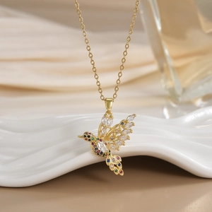 Macro detail of bird pendant with vibrant colorful cubic zirconia in gold plating