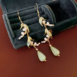 Detail of lily of the valley earrings with green enamel leaves and drop gemstones