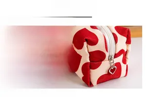 Detail of a smooth white resin zipper and a golden heart metal puller on a canvas makeup bag