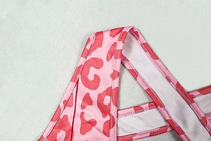 Détail macro du tissu à imprimé léopard rose avec coutures précises sur la combinaison