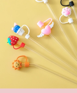 Detail of colorful silicone cartoon dust caps on transparent glass straws shown up close