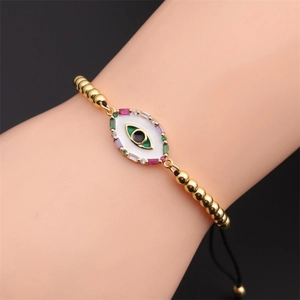 Détail du bracelet Œil maléfique plaqué or avec zircons colorés porté sur le poignet