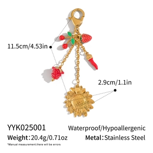 Détail des breloques tournesol et fraise sur un porte-clés en acier inoxydable
